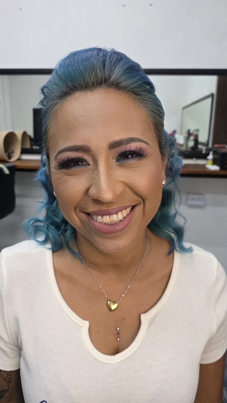 Modelo sonriendo con maquillaje de ojos en tonos rosa y lila, trabajo de Atelier 13