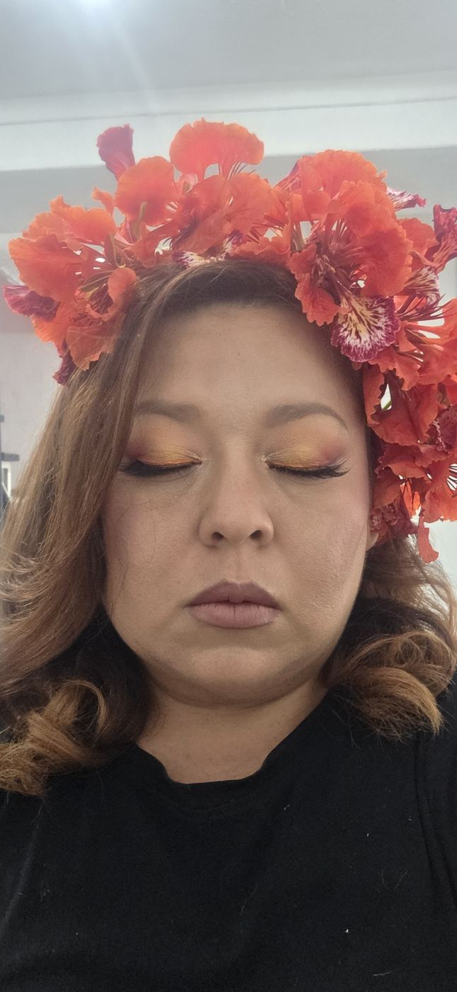Look de evento con tocado de flores rojas y sombra cálida